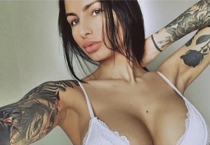 Portrait boudoir d&rsquo;une femme en lingerie blanche, bras tatou&eacute;s